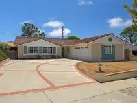 Single-story house with large driveway in California.
