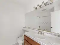 bathroom with large mirror with marble countertop in California.
