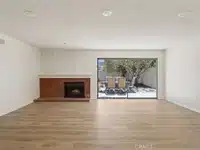 empty living room with brick fireplace and large sliding glass doors in California.