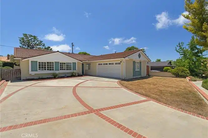 Single-story house with a red-tiled roof and white exterior in California.