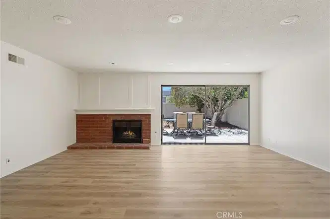 Living room with light wood flooring, a red brick fireplace in California.