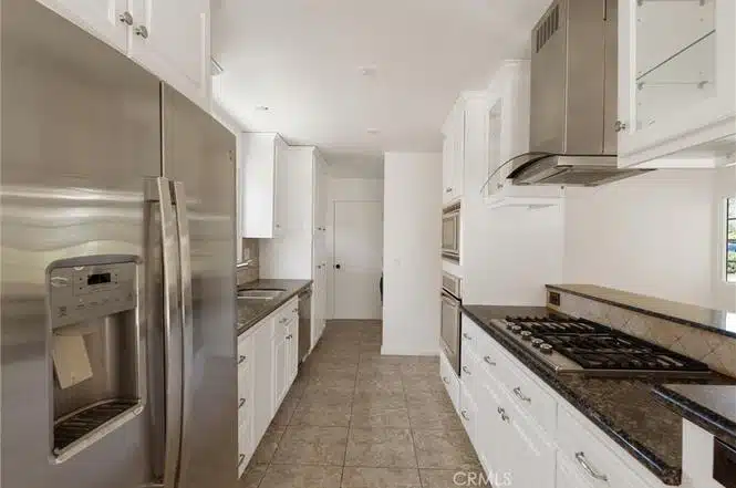 kitchen with stainless steel refrigerator and granite countertops in California.