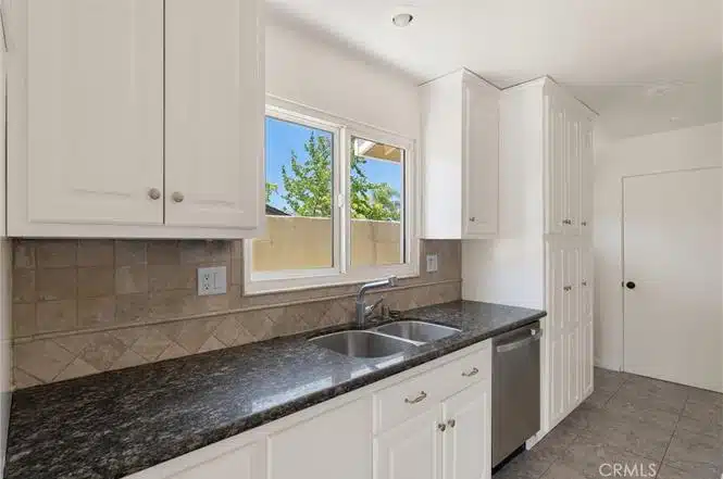kitchen with white cabinets and black granite countertops in California.