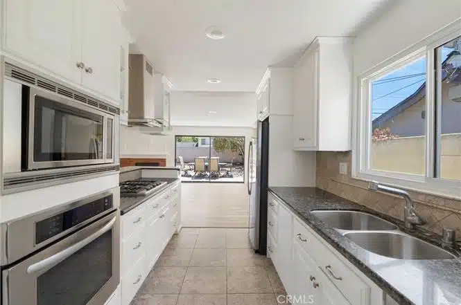 kitchen with white cabinets, gray countertops, stainless steel appliances in California.