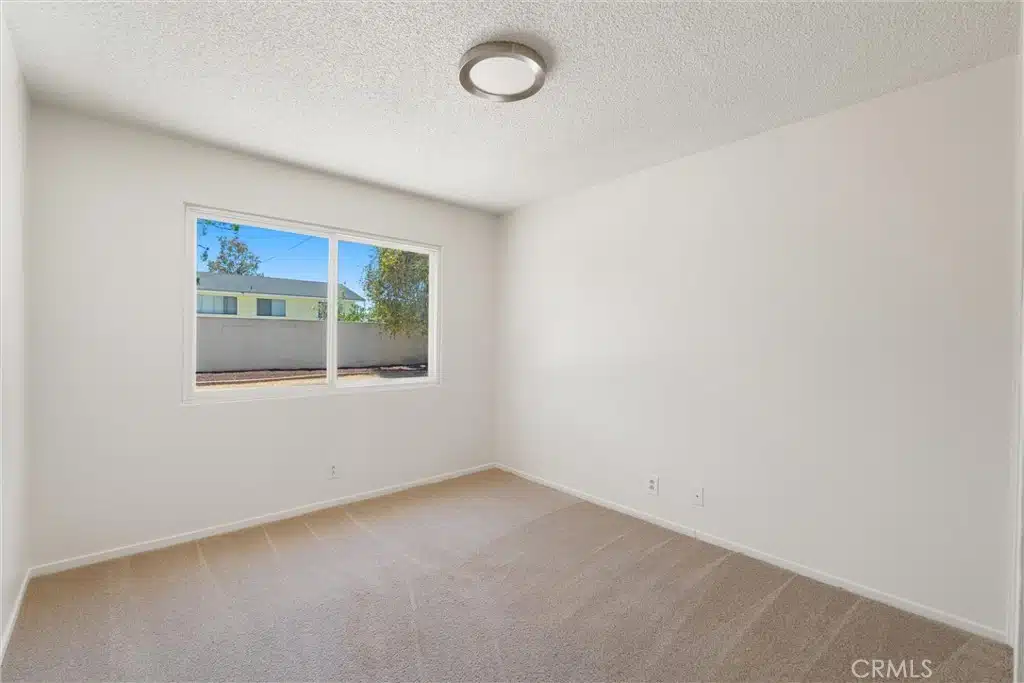 room with a large window and a carpet in California.