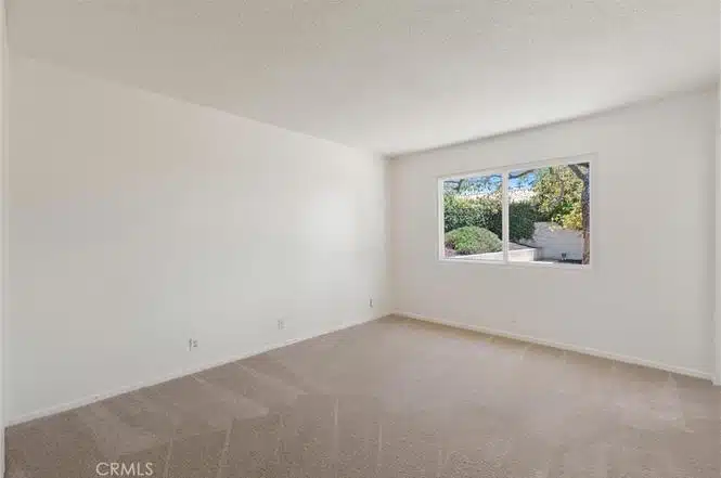 Empty room with carpet and a window in California.