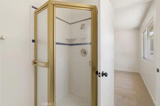 bathroom with tiled shower and glass door in California.