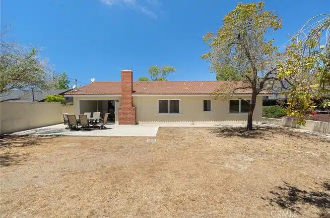 single-story house with a red-tiled roof and large windows in California.