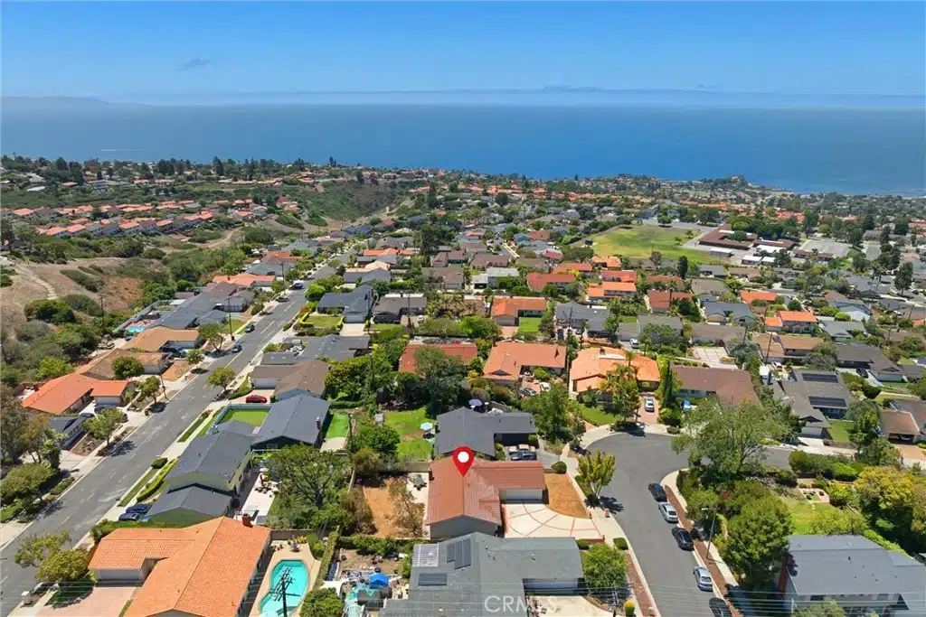 Aerial view of a coastal neighborhood with rows of houses in California.