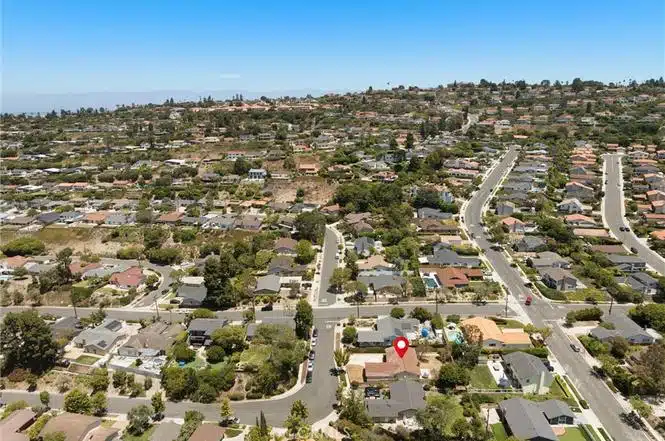 Aerial view of a suburban neighborhood with red location pin marks a specific house in Blythe