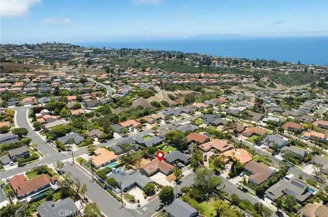 Aerial view of arranged houses and overlooking a blue ocean in California.