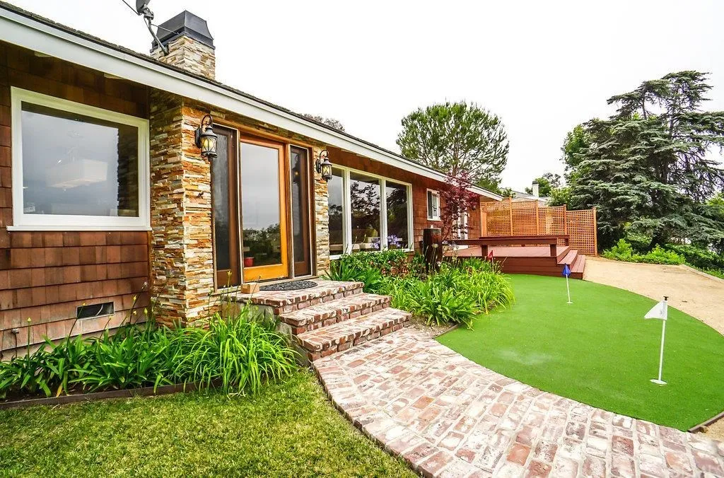 house with green and wooden deck in California.